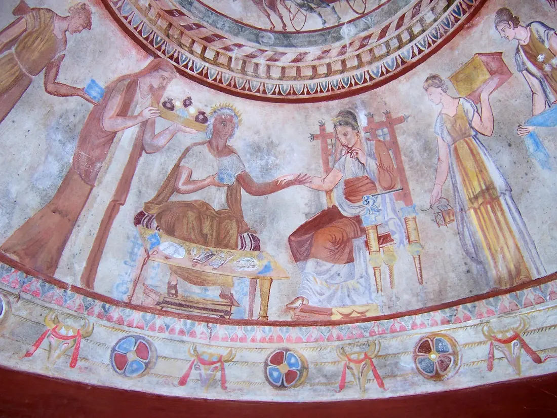 The funeral feast scene in the domed chamber of the Kazanlak tomb replica, with a seated couple holding hands and attendants bringing gifts