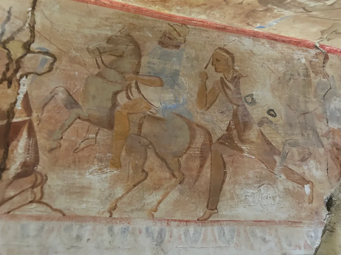 Damaged fresco of mounted warriors in the corridor of the original Kazanlak tomb, streaked with pale mineral deposits