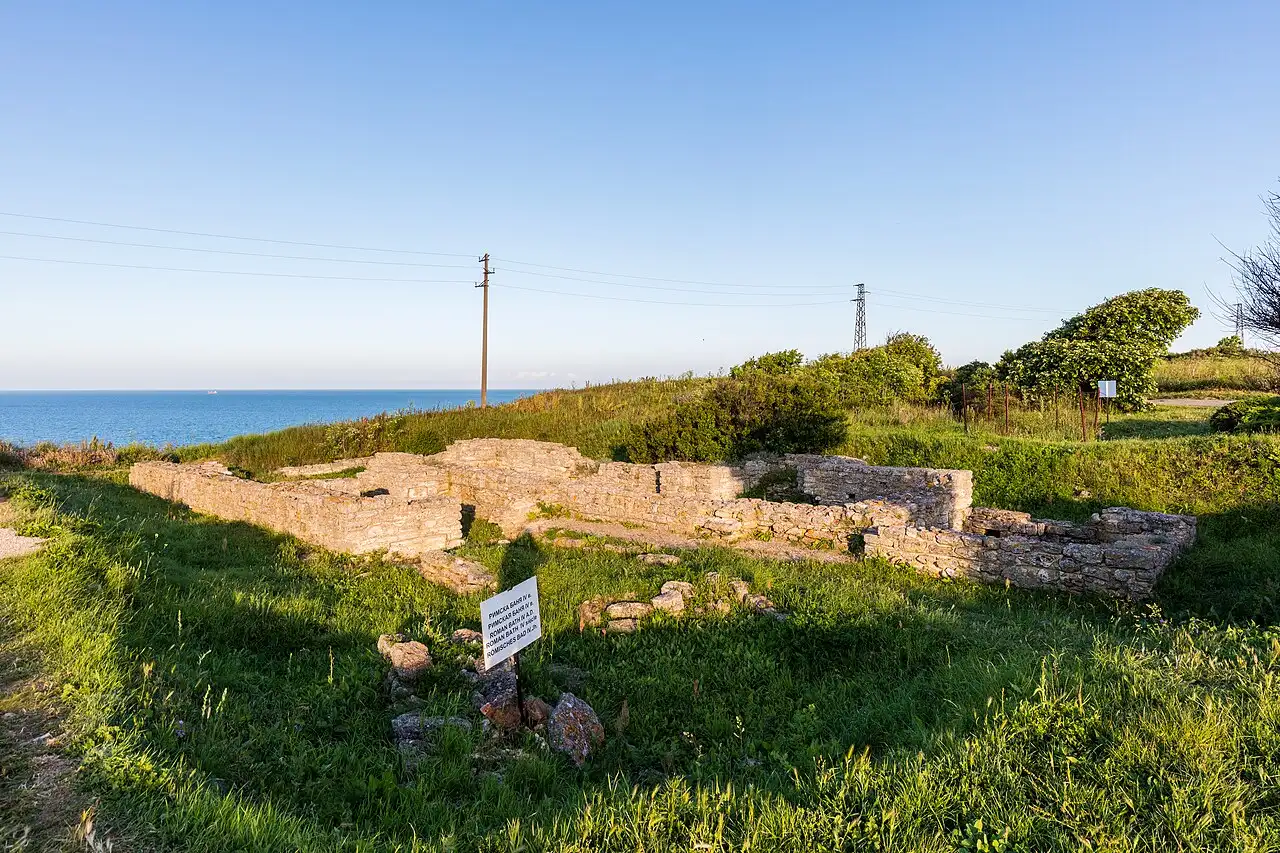 Fortress wall ruins on the edge of Cape Kaliakra with red cliffs and blue sea below