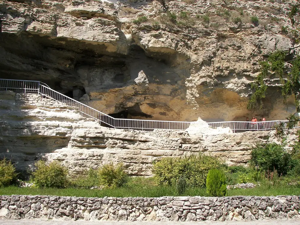 The limestone cliff of Aladzha Monastery with metal walkways and stairs leading to the rock-cut cells