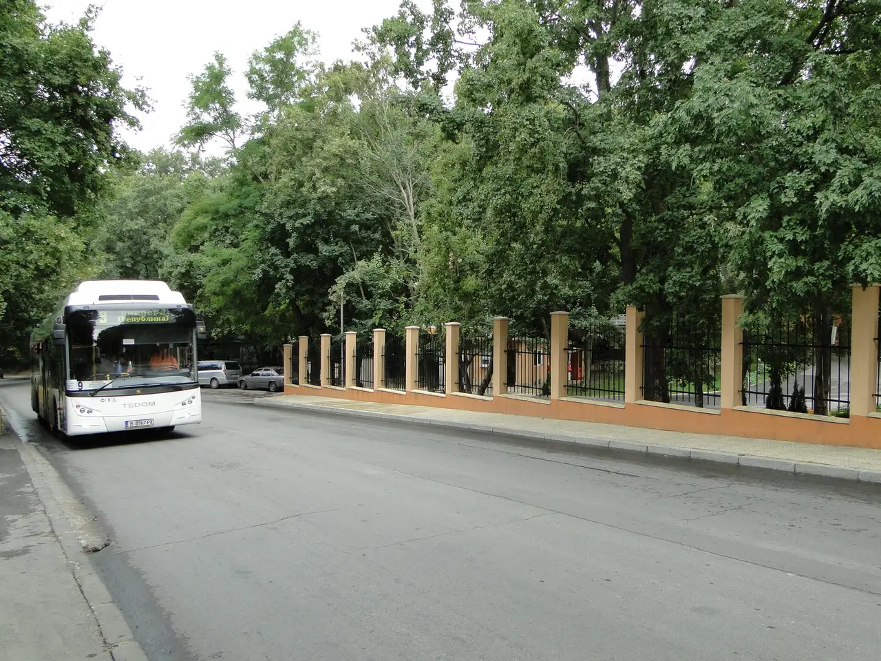 A white Varna city bus signed for route 9 to Republika standing on a tree-lined street at Golden Sands
