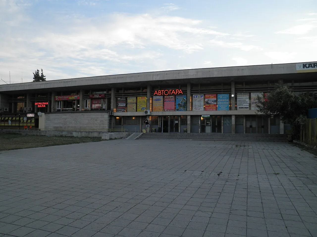 Passengers and coaches at a Bulgarian intercity bus station forecourt