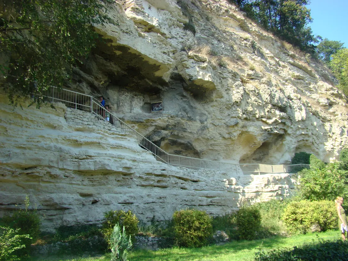 The Aladzha rock monastery near Varna: cells and a chapel cut into a high pale limestone cliff, reached by a stone staircase