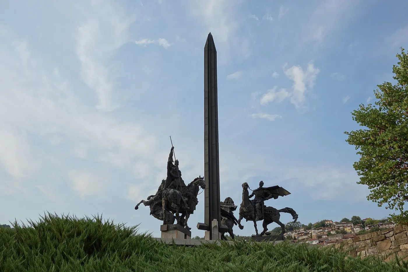 The Asenevtsi Monument in Veliko Tarnovo: four bronze mounted tsars circling a tall vertical sword against the sky