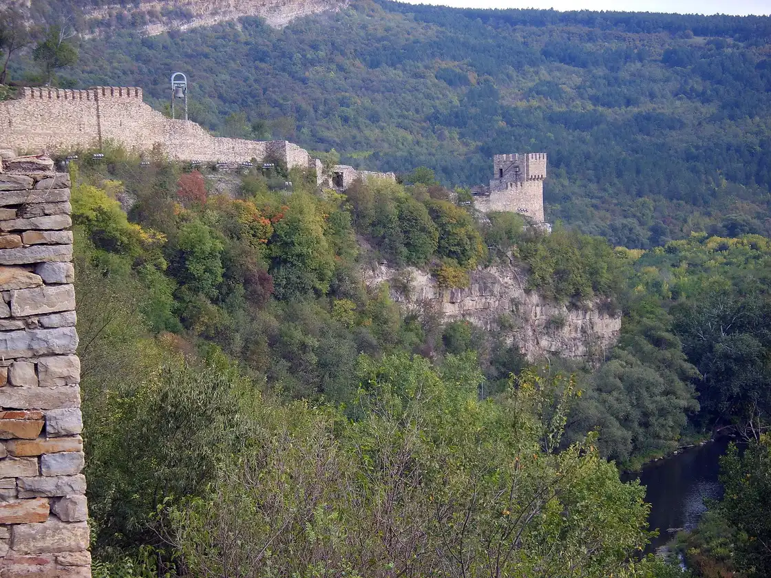 Baldwin's Tower and the stone ramparts of Tsarevets running along the cliff edge above the wooded Yantra gorge
