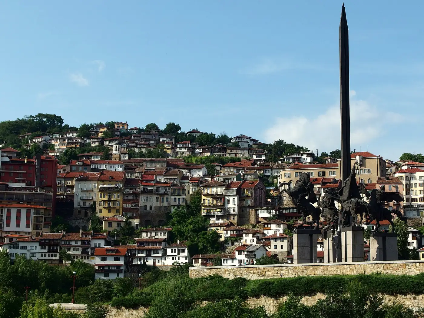 Old town houses of Veliko Tarnovo stacked in tiers up the green hillside above the Yantra gorge