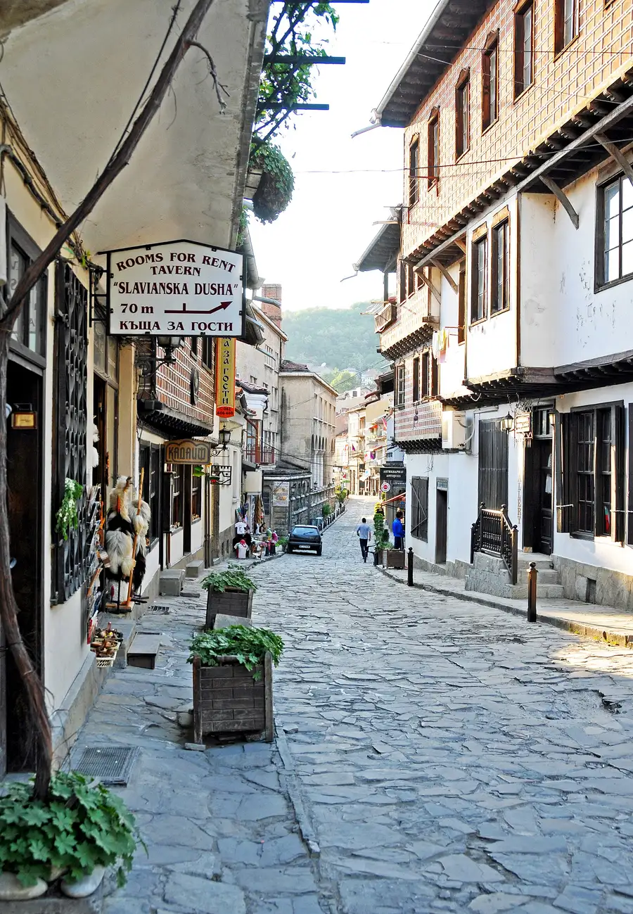 A cobbled old-town street in Veliko Tarnovo lined with balconied Revival houses, craft shops and antique dealers