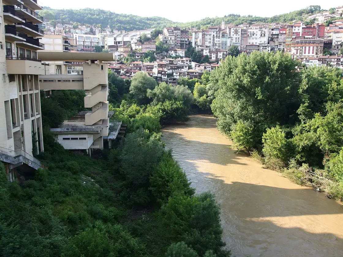 The muddy green Yantra river curling below the tiered houses of Veliko Tarnovo old town