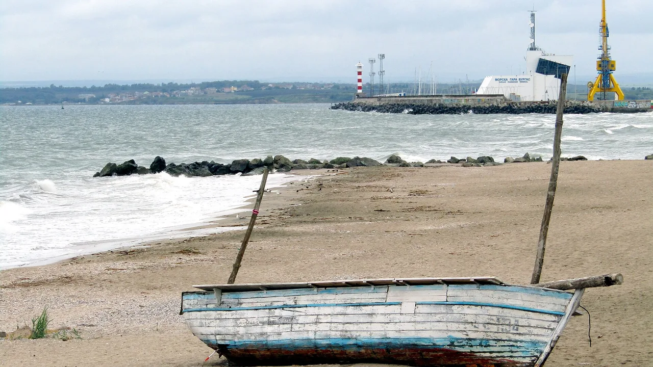 Burgas Central Beach on a clear day, sand and low surf under a pale blue sky with the bay stretching out