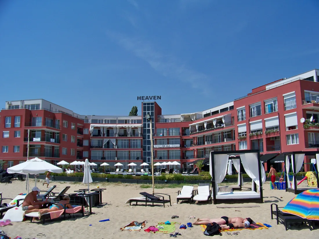 Low-rise beachfront apartment blocks in Sunny Beach with sunloungers and beach beds on the sand in front