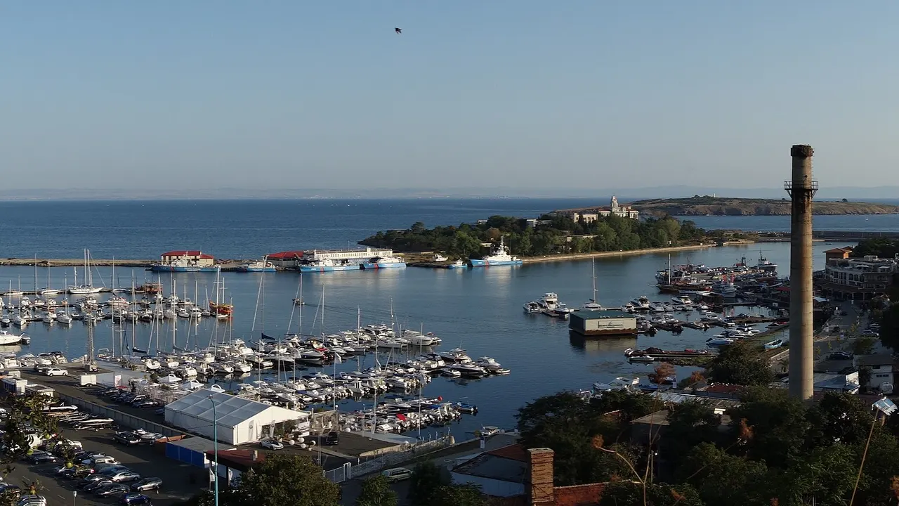 Sozopol harbour full of yachts with the old-town peninsula, the landmark chimney and St Ivan island beyond
