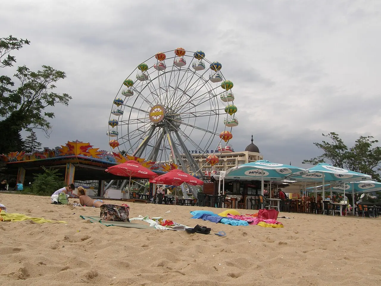 The beach at Golden Sands resort north of Varna, with a colourful funfair Ferris wheel, beach bars and a large domed hotel behind the sand