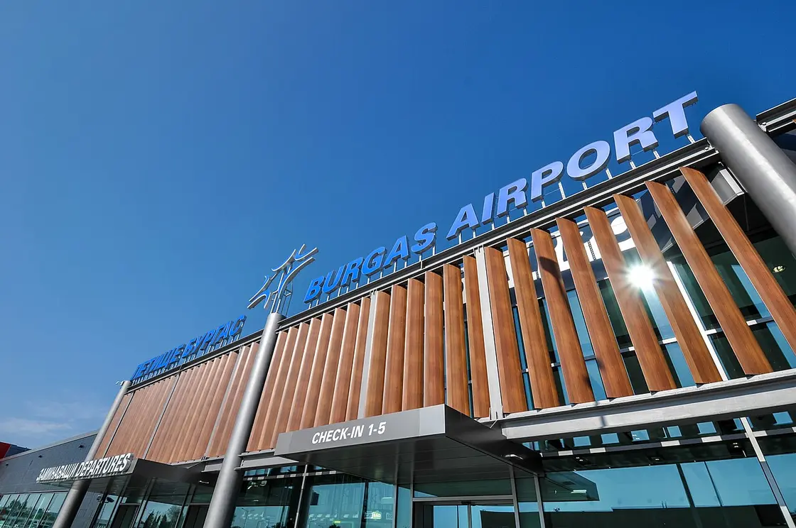 The modern terminal building of Burgas Airport with its glass facade and passengers outside the entrance