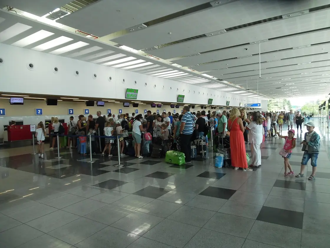 The check-in hall inside Burgas Airport with rows of desks and departure boards