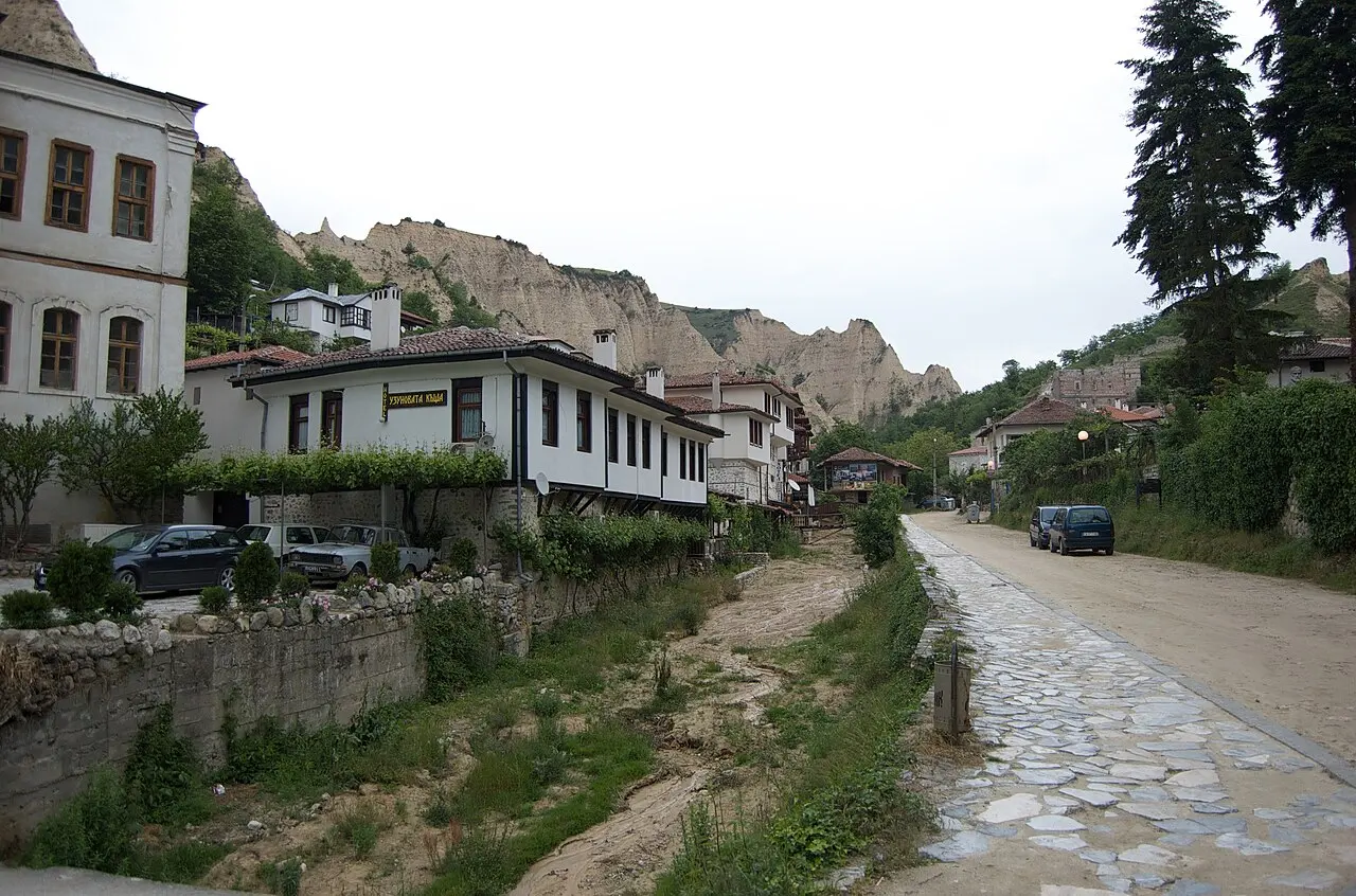 The town of Melnik with white Revival houses below dramatic sandstone pyramids in south-west Bulgaria