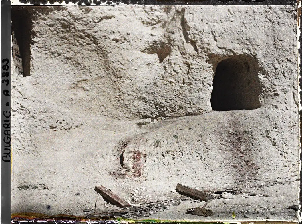 Wine-cellar doorways carved into the pale sandstone cliffs at Melnik, with old traces of spilled wine
